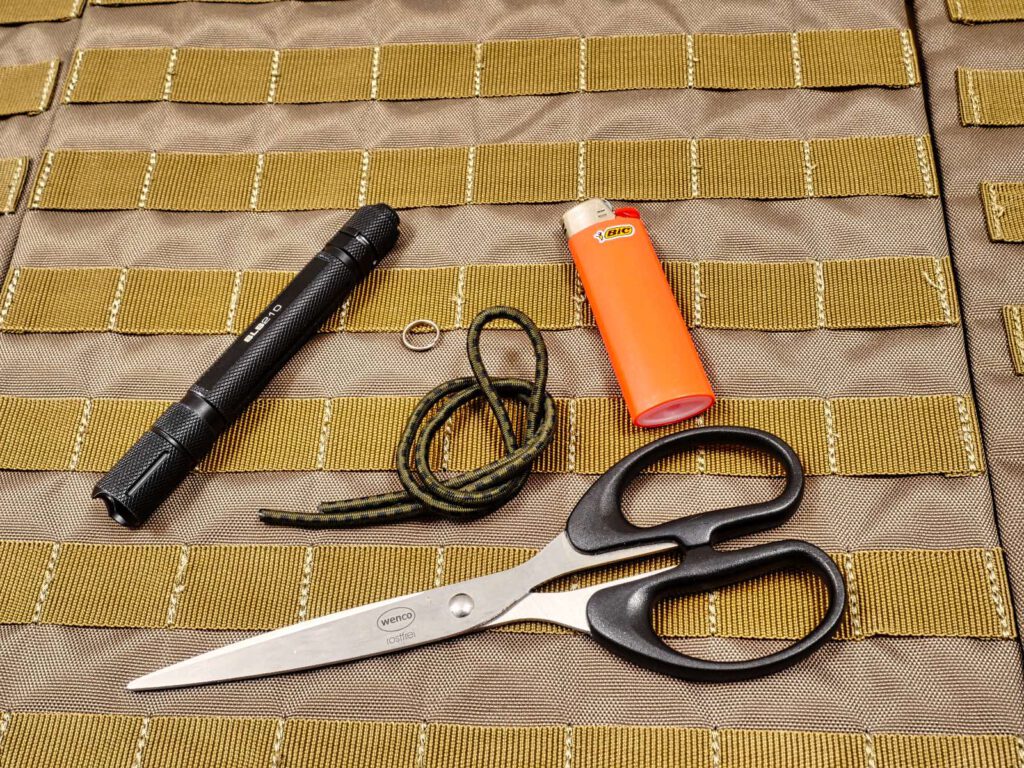 Das wird benötigt: Taschenlampe, Schlüsselring, etwa einen halben Meter Flexcord, Schere und Feuerzeug